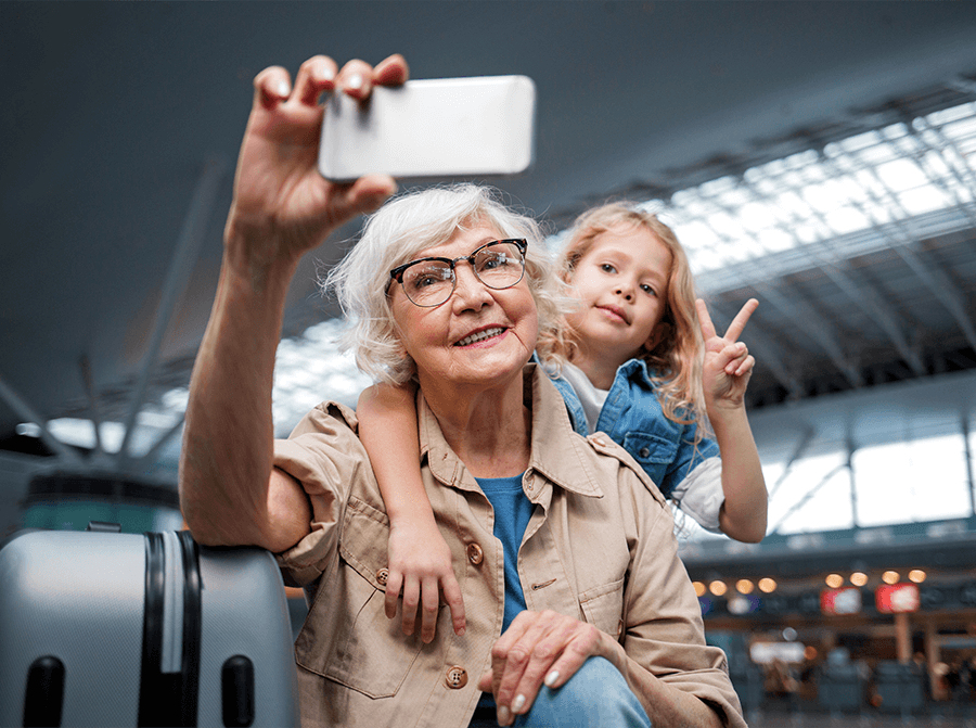 senior z wnuczką używają smartfona do selfie