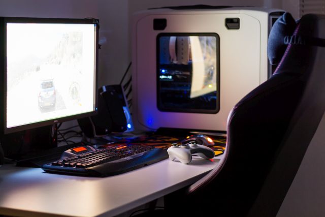 Stanowisko komputerowe przygotowane do pracy: monitor, komputer i krzesło z podpórką.