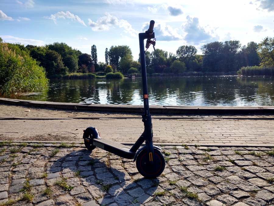 hualjnogaelektryczna Xiaomi Mi Electric Scooter Pro2 2022 stoi nad stawem w parku i rozmyśla gdzie pojedzie