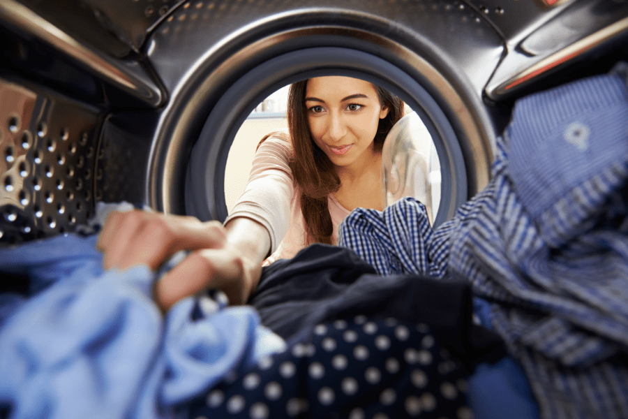 Osoba wyciągająca ubrania z pralki