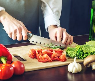 Szef kuchni szatkuje warzywa nożem
