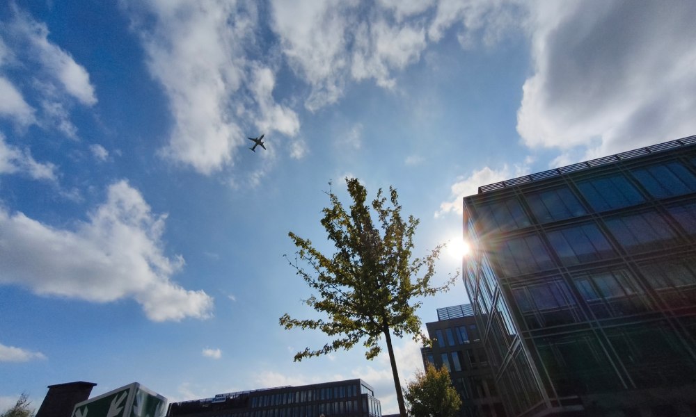 szeroki kąt, zdjęcie samolotu startującego nad dzielnicą biurową