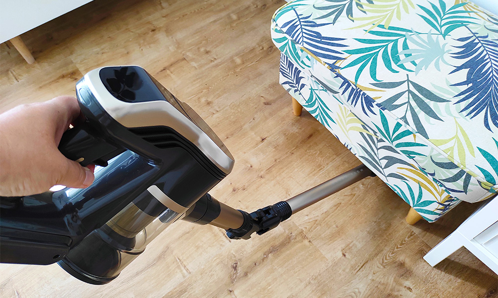 Test odkurzacza Mova S2 Detect - odkurzanie pod pufą, rura odkurzacza jest zgięta