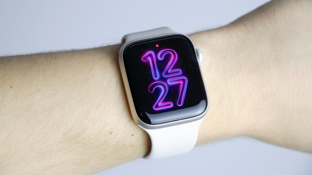 Apple Watch SE 3 pokazujący godzinę dwunastą dwadzieścia siedem na tarczy Pride