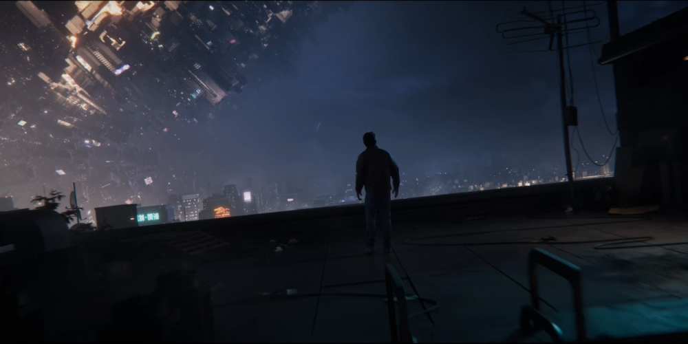 mężczyzna stojący na dachu, wpatruje się w nocne miasto