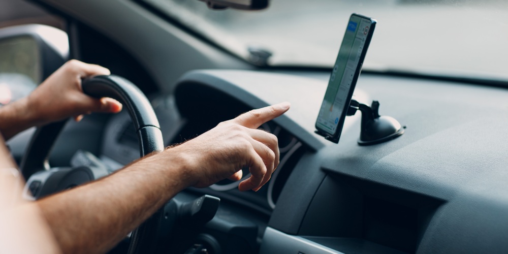 smartfon zamocowany na desce rozdzielczej samochodu