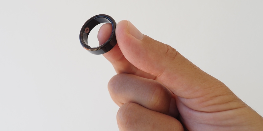 Dłoń trzymająca czarny smart ring