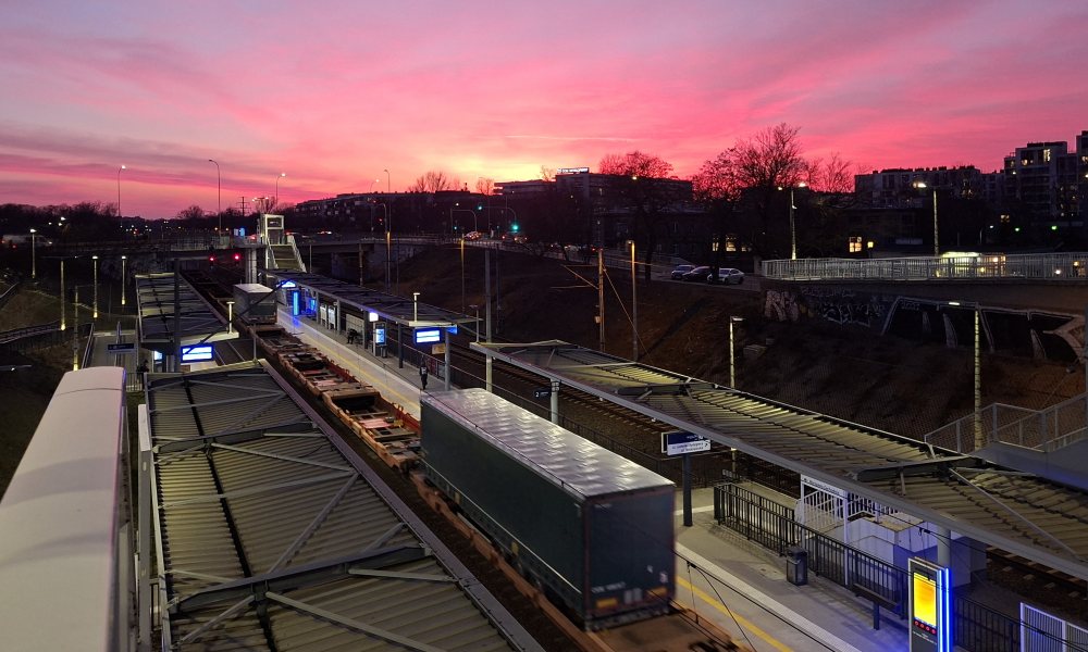 wieczorne zdjęcie r&oacute;żowego nieba nad torami kolejowymi