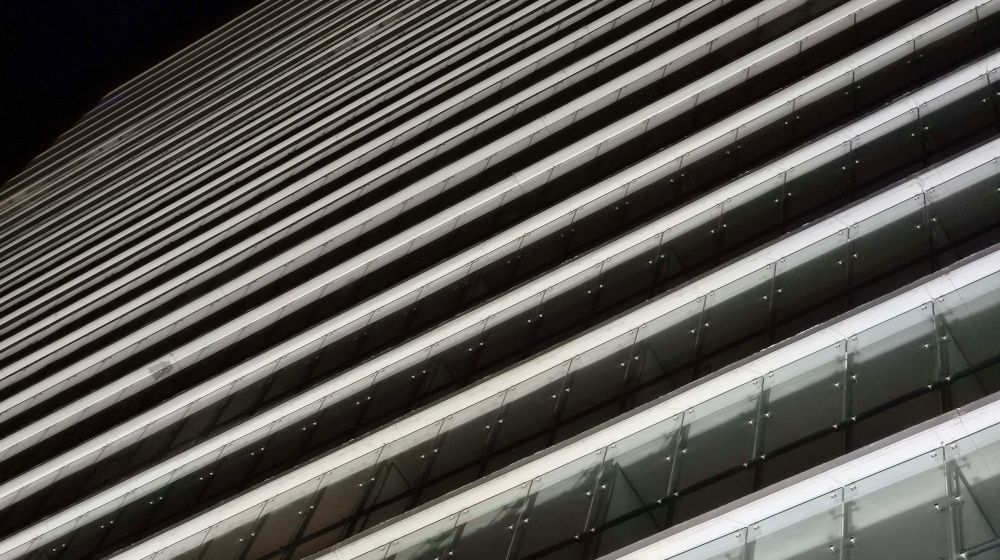 Noc, oświetlony blok Shanghai w Warszawie z dolnej perspektywy