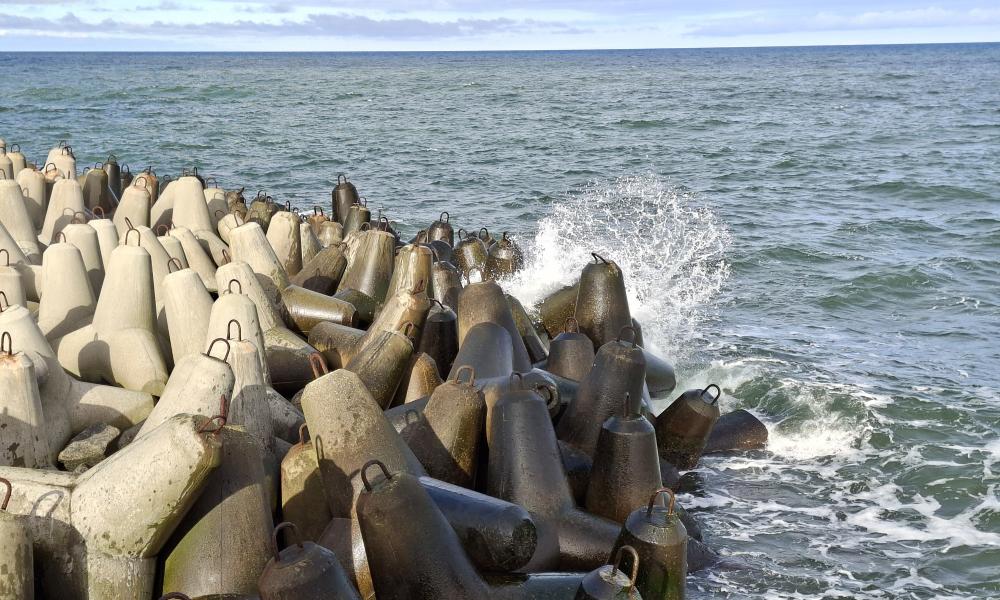 morskie fale rozbijające się o falochron