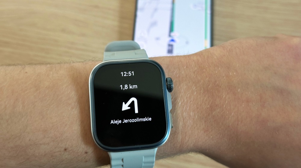 błękitny smartwatch z ekranem nawigacji pokazjącym strzałkę skrętu w lewo