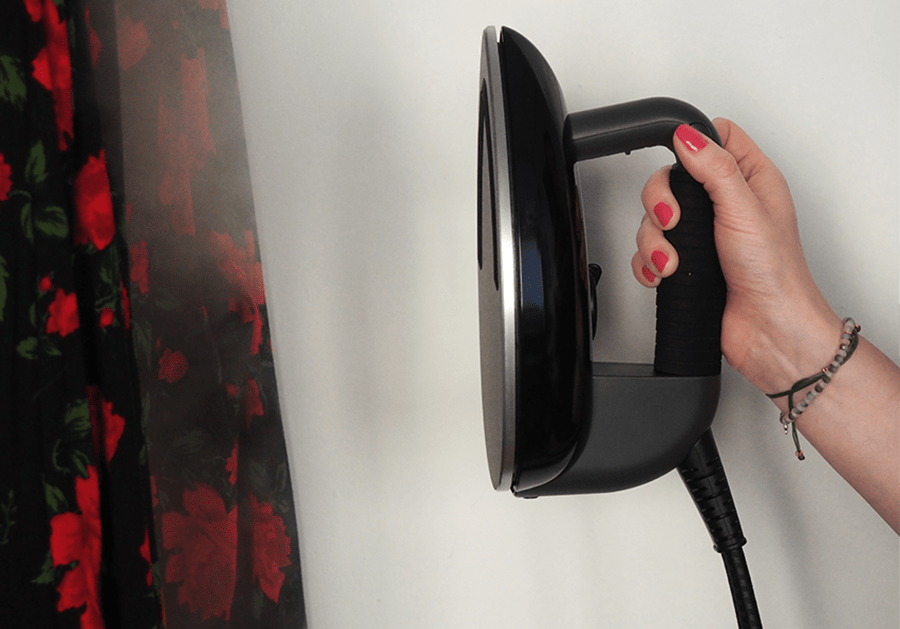 żelazko parowe trzymane w dłoni