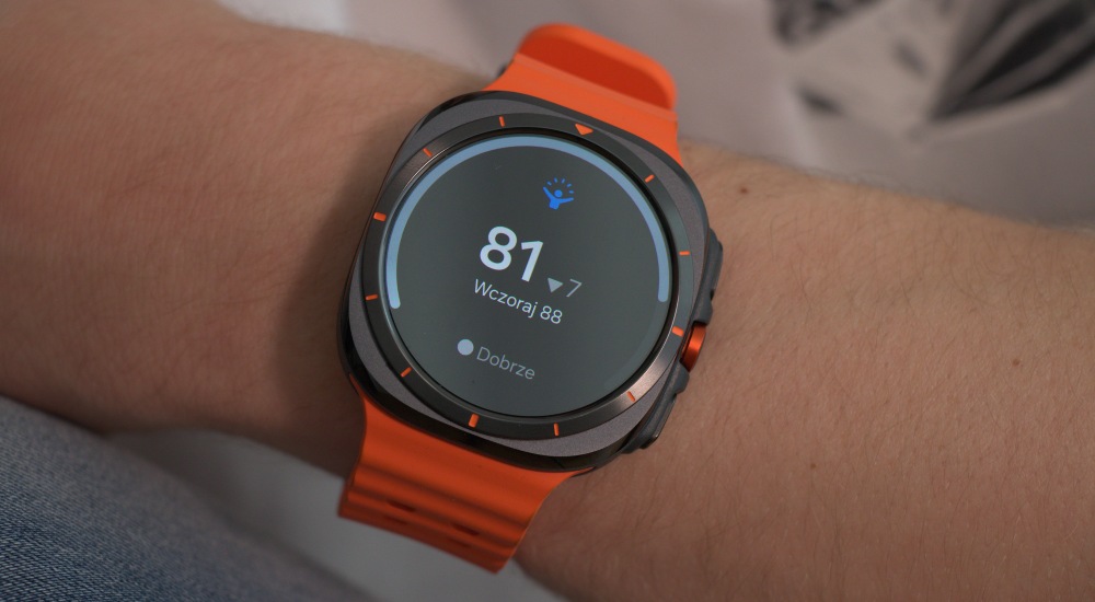 inteligentny zegarek Samsung Galaxy Watch Ultra z pomarańczowym paskiem pokazuje dobry wynik energii
