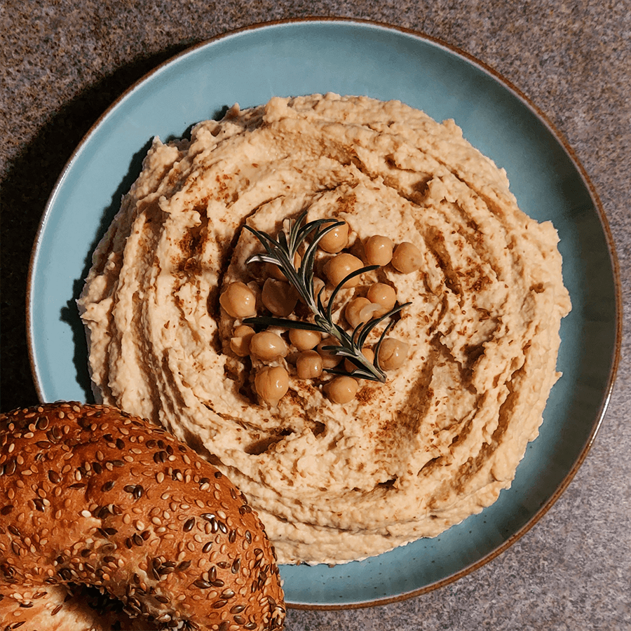 Hummus klasyczny zrobiony w termorobocie, podany na talerzyku z bajglem