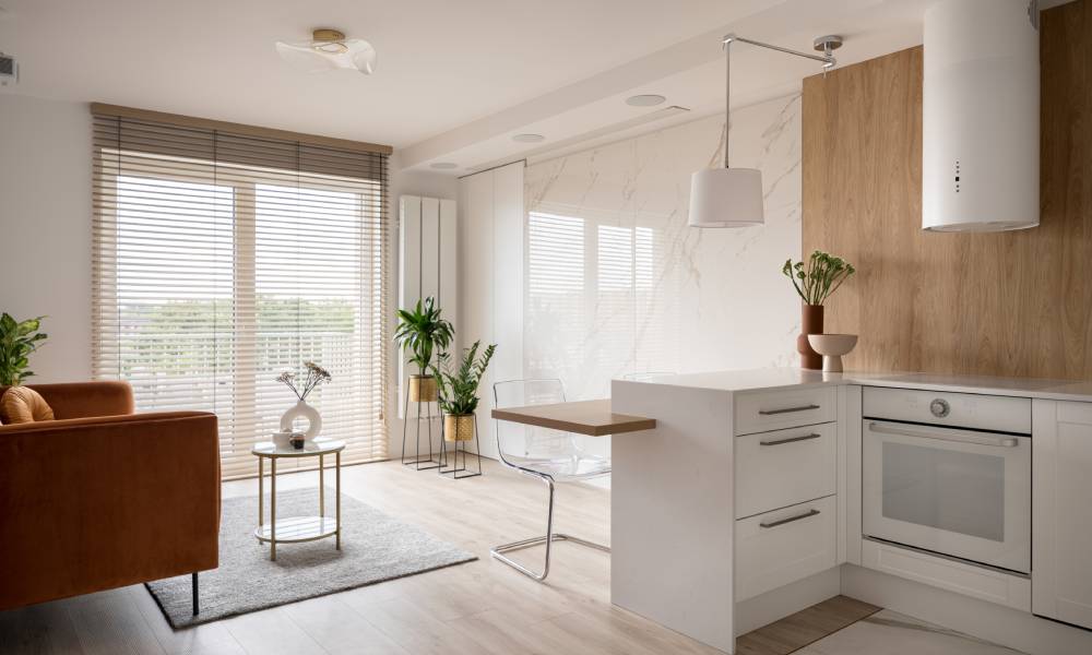 Mała kuchnia z salonem w otwartym planie, z małym p&oacute;łwyspem, kt&oacute;ry pełni funkcję stołu