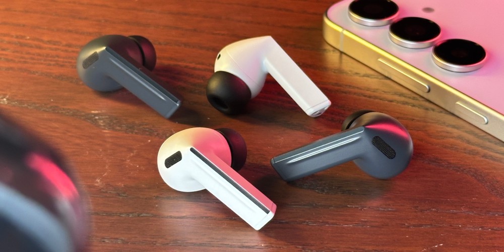 czarne i szare słuchawki Samsung Galaxy Buds3 FE leżące na drewnianym stole