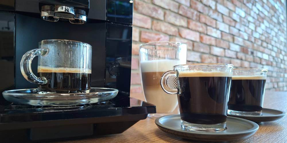 Espresso zaparzone podczas testu ekspresu Jura A8, obok stoją inne kawy czarne i mleczna