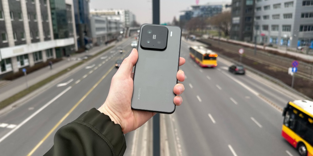 Smartfon Xiaomi 15 w czarnej wersji kolorystycznej na tle szarego deszczowego miasta