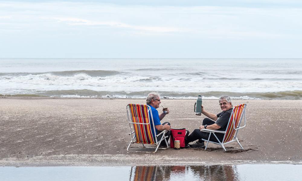 mężczyźni piją yerba mate na plaży