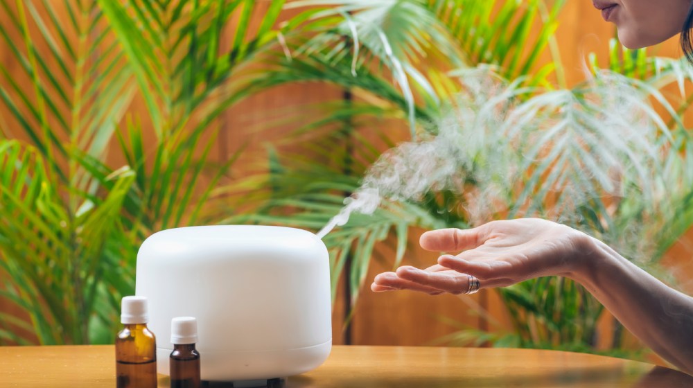 kobieta wąchająca aromaty z dyfuzora zapach&oacute;w