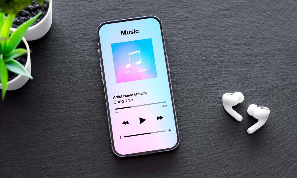 Bezprzewodowe słuchawki dokanałowe w białym kolorze leżące obok smartfona.
