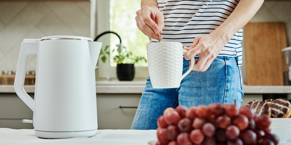 kuchnia z białym czajnikiem elektrycznym stojącym na blacie