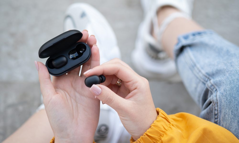 Bezprzewodowe słuchawki dokanałowe w czarnym etui.