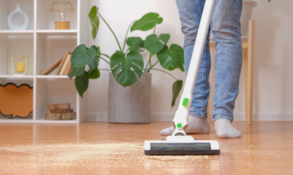 osoba z odkurzaczem pionowym odkurza piasek