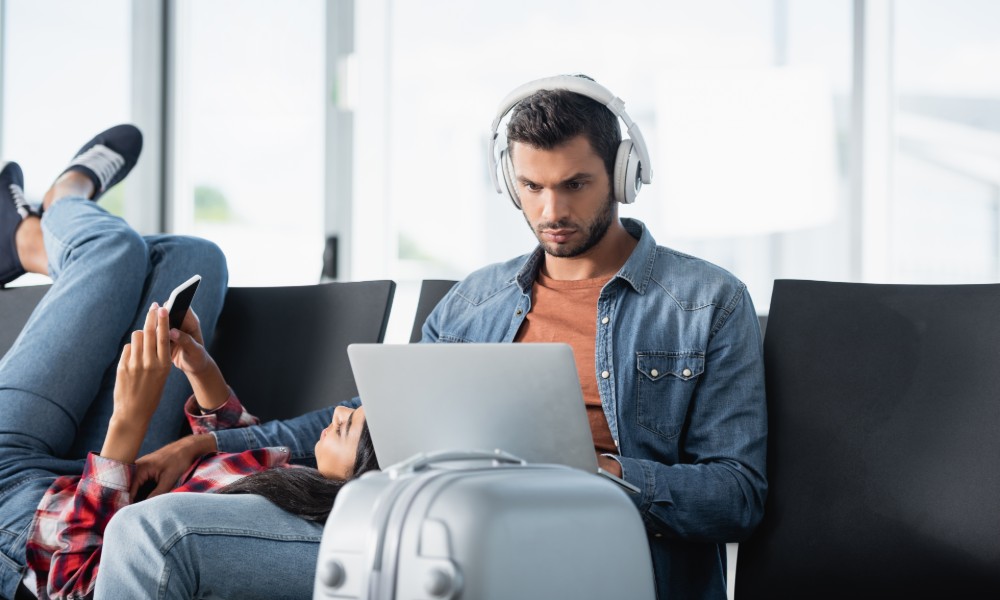 mężczyza korzystający z laptopa na lotnisku