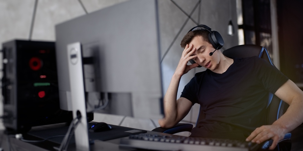 gracz siedzi przed komputerem zawiedziony