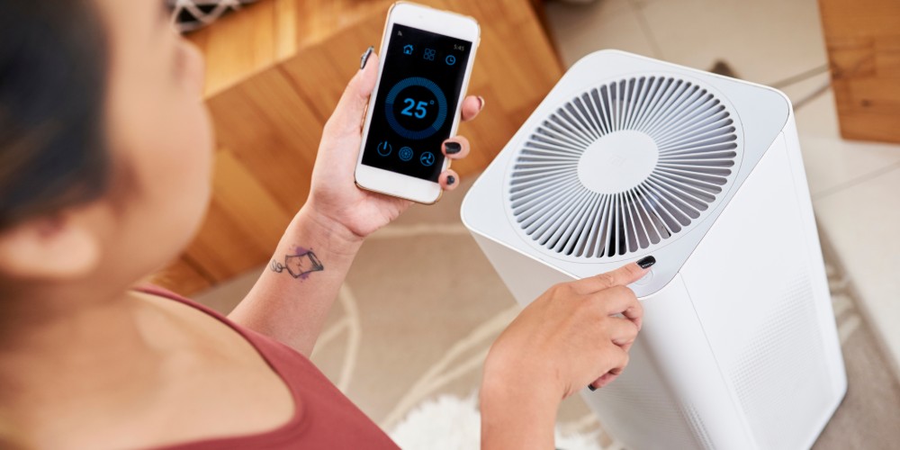 Kobieta uruchamiająca klimatyzator przenośny