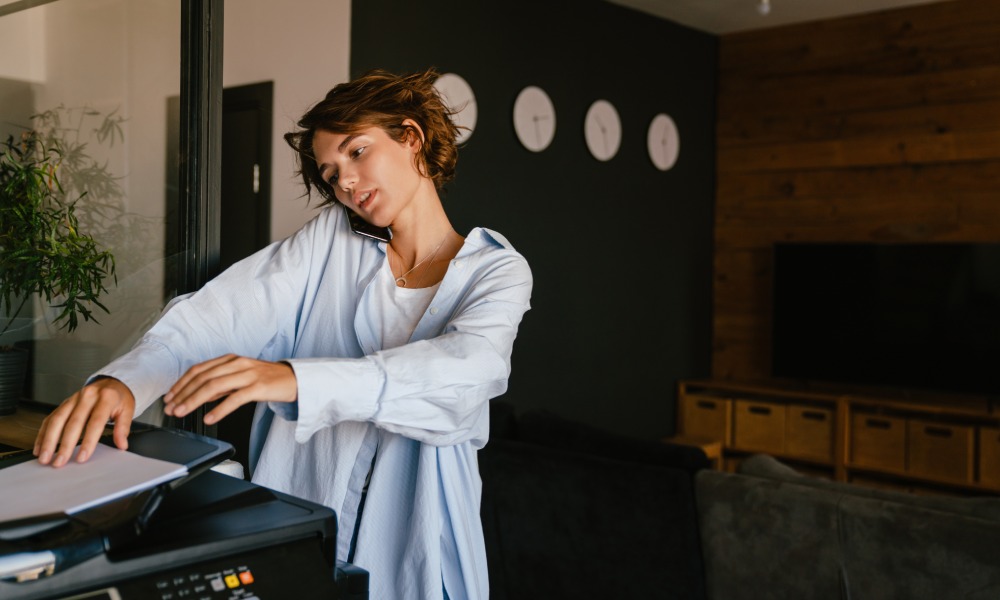 kobieta rozmawia przez telefon i korzysta z drukarki