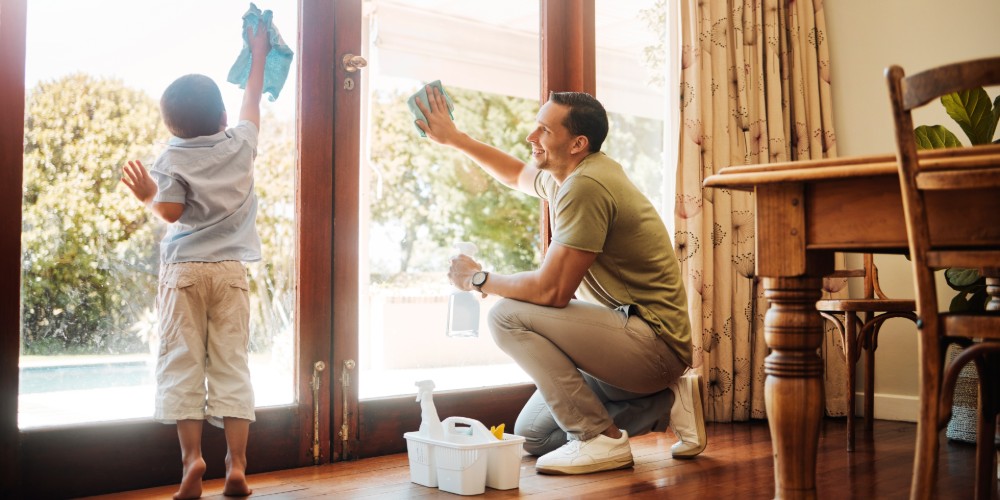 Mężczyzna myjący okno z synem