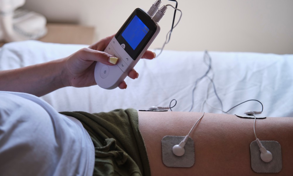 Kobieta używająca elektrostymulatora na udzie