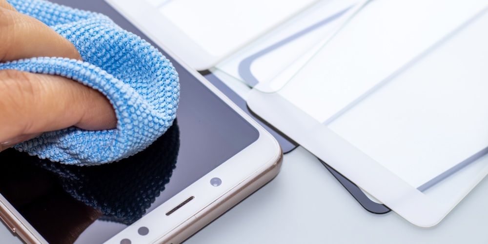 czyszczenie ekranu telefonu niebieską ściereczką z mikrofibry