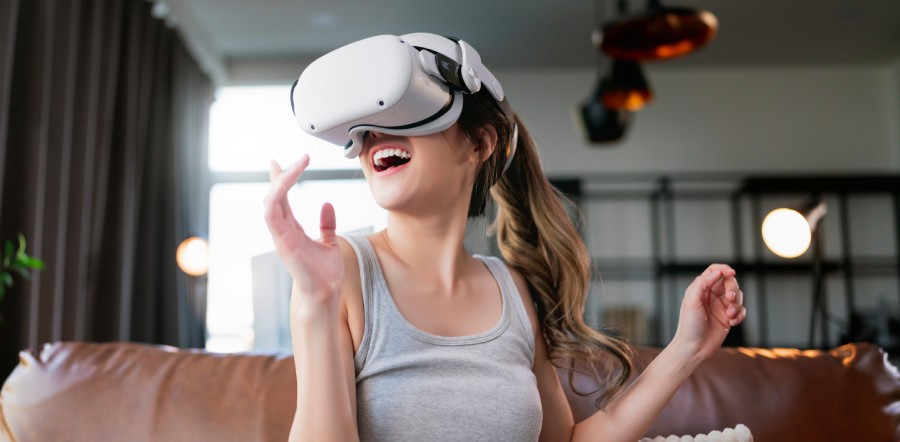 Uśmiechnięta kobieta korzystająca z gogli VR