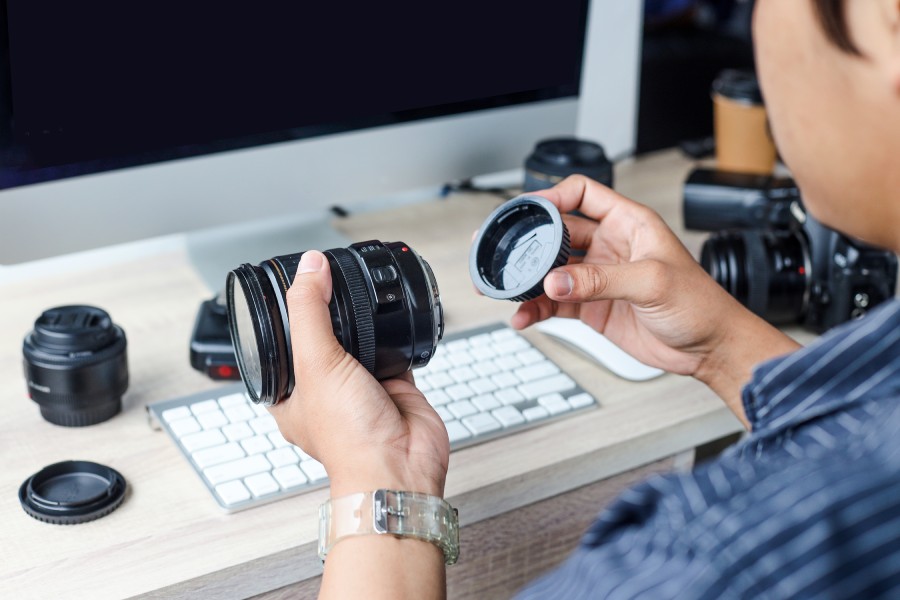 mężczyzna trzyma w rękach obiektyw