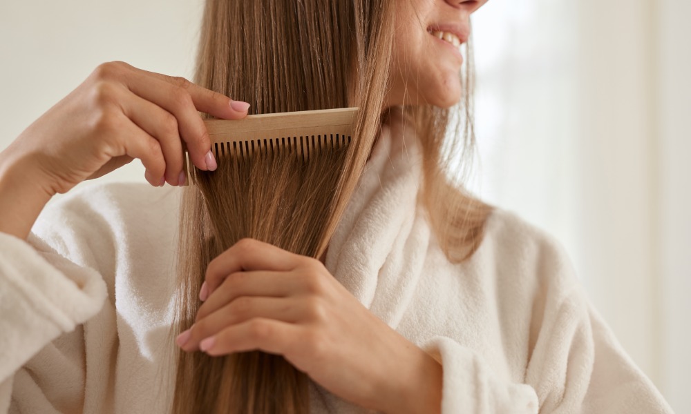 kobieta czesze grzebieniem długie brązowe włosy