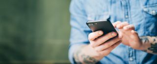 Mężczyzna trzymający w dłoniach smartfon