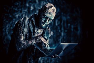 Zombie używający laptopa w ciemności