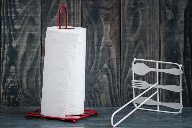 Prosty stojak na ręczniki papierowe z rolką papieru obok przewróconego stojaka bez papieru