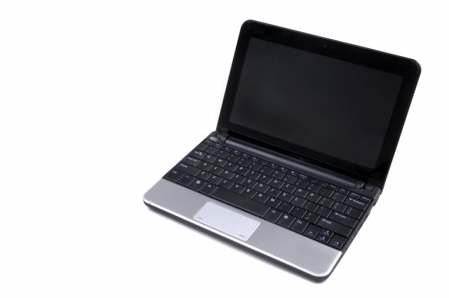 Mały szary laptop rozłożony na białym tle