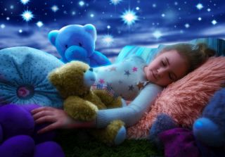 Dziewczynka śpiąca przy rozgwieżdżonym niebie z projektora