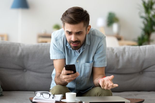 Mężczyzna irytujący się na swój smartfon