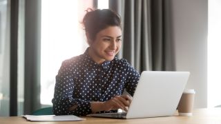 Kobieta korzystająca z laptopa w oświetlonym, nowoczesnym pokoju