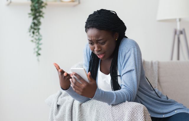 Kobieta złości się na swój wyłączający się smartfon