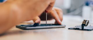 Mężczyzna naprawia resetujący się smartfon