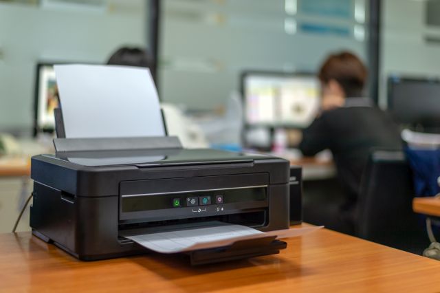Czarna drukarka na biurku w biurze