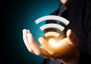 Podświetlony symbol dostępu do sieci Wi-Fi podtrzymywany przez dłoń