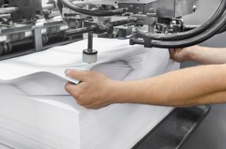 ręce zmieniają ryzę papieru w druku